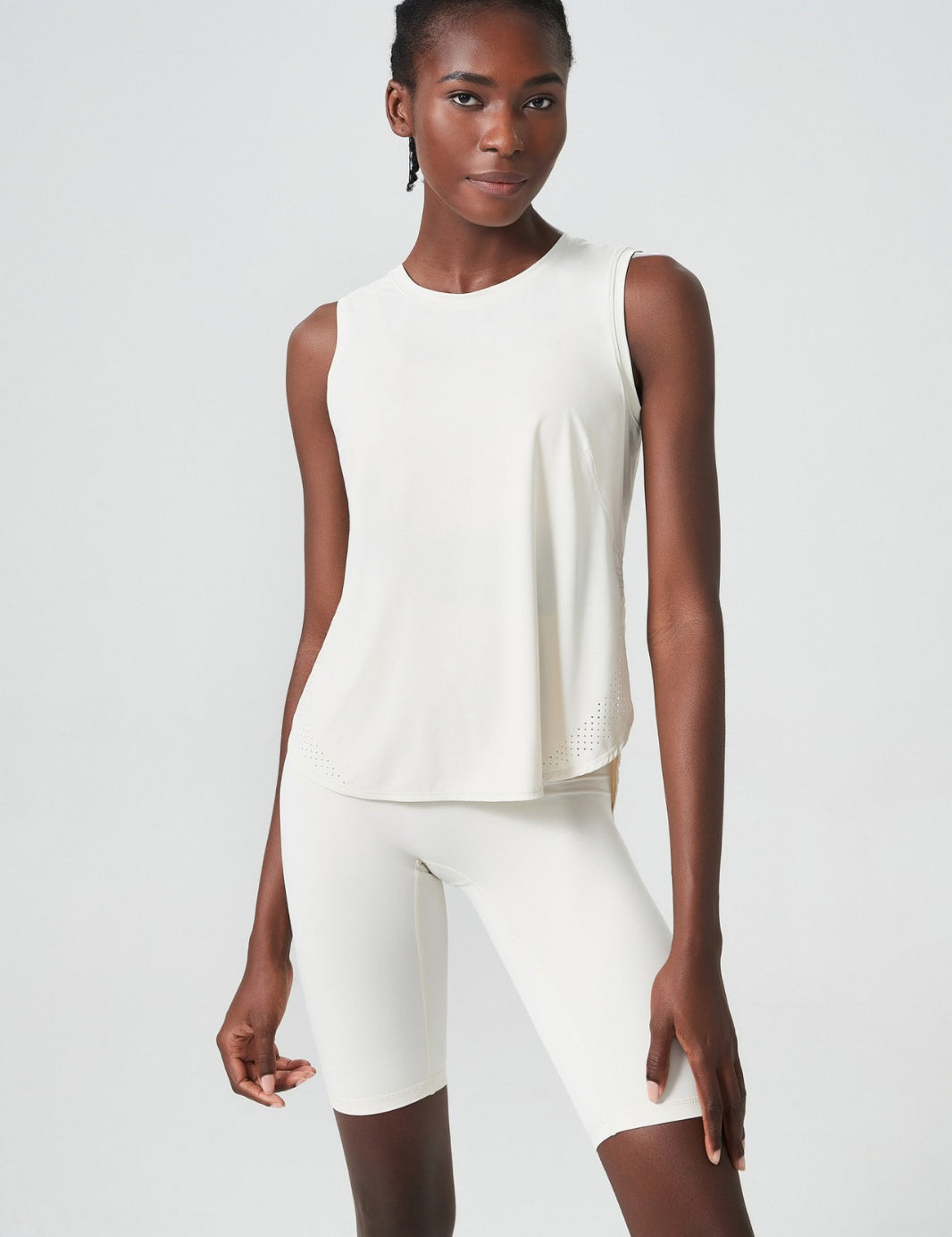 A woman wearing a black sleeveless performance tank top with moisture-wicking fabric, designed for activewear.