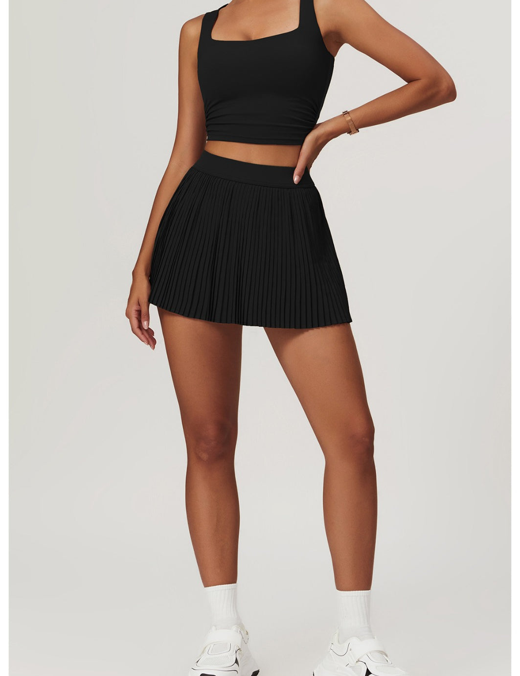 Person wearing a black skort outfit with a white background