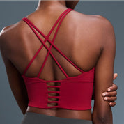 Red sports bra with strappy back design on a gray background